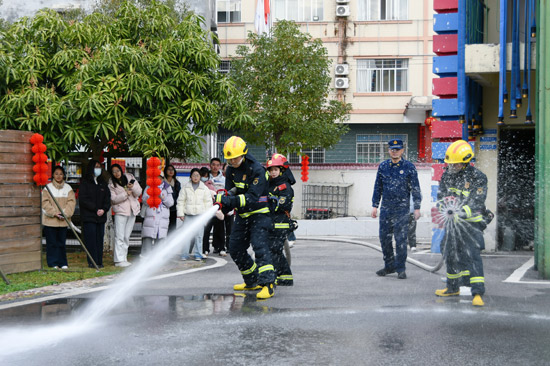 志愿者們穿上滅火戰(zhàn)斗服體驗手持水槍進(jìn)行“滅火”（馮韻詩 攝）